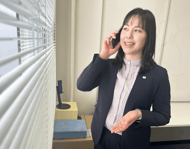 オフィスの窓際でお客様と電話